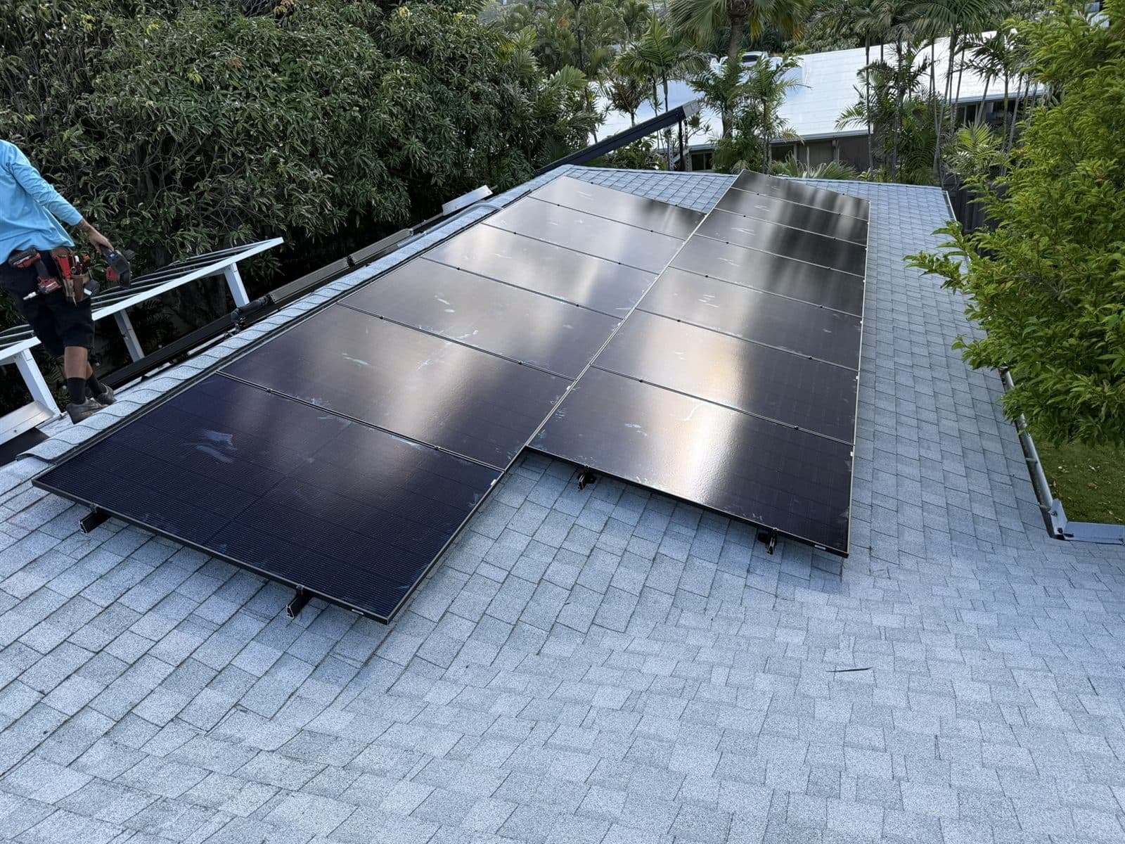 Installer working on a rooftop solar array on Oʻahu